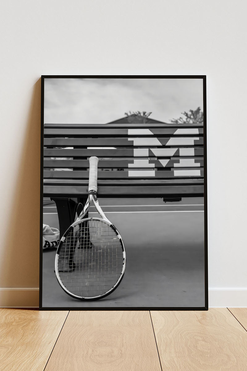 Close-up Poster mit Rahmen eines Tennisschlägers angelehnt an eine Bank auf einem Tennisplatz in schwarz weiß