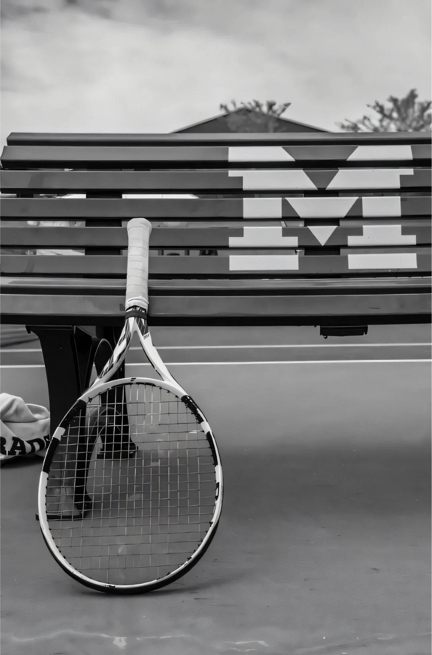 Nahaufnahme Poster mit Rahmen eines Tennisschlägers angelehnt an eine Bank auf einem Tennisplatz in schwarz weiß