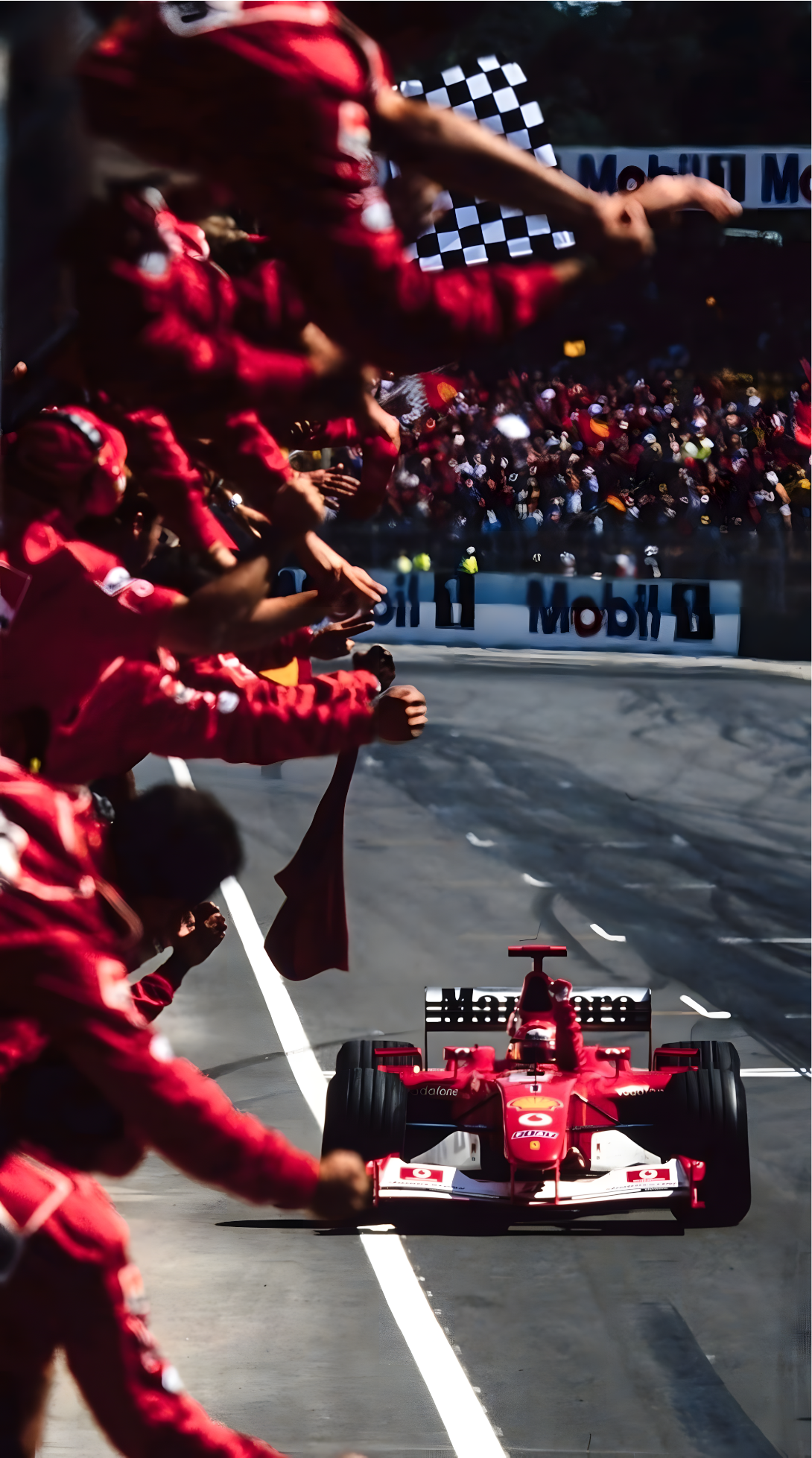 Nahaufnahme Poster mit Rahmen Michael Schumacher fährt über Zielline beim Formel 1 Rennen und sein Team Jubelt mit Ferrari in rot blau grau schwarz weiß